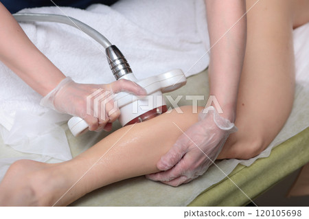 Hardware shin lift is performed in beauty salon. Fight against cellulite. Shin massage. Skin tightening. Concept of beauty and health. Hardware shin lift is performed in beauty salon. Fight against cellulite. Shin massage. Skin tightening. Concept of beauty and health. 120105698