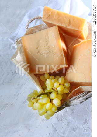Large chunks of hard cheese. Aged hard cheese of the parmesan type. Vertical photo. Large chunks of hard cheese. Aged hard cheese of the parmesan type. Vertical photo. 120105714