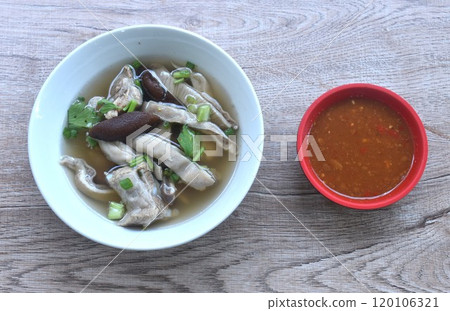 boiled slice pork stomuch and bone soup in bowl dipping spicy sauce cup on table boiled slice pork stomuch and bone soup in bowl dipping spicy sauce cup on table 120106321