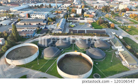Bio gas station factory plant modern aerial drone view, ecological biomass energy production round roofs biofuel large distribution technological complex, technology distillation pollution, Europe 120106547