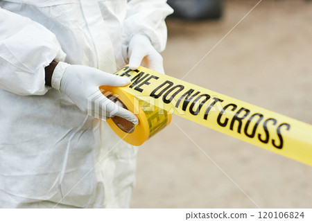 Close up of unrecognizable person wearing hazmat suit unrolling Do not cross tape outdoors and fencing off dangerous site, copy space Close up of unrecognizable person wearing hazmat suit unrolling Do not cross tape outdoors and fencing off dangerous site, copy space 120106824