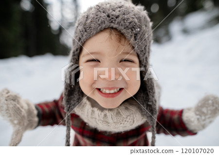 Portrait of small girl enjoying winter holiday in the mountains with family, playing in snow. Portrait of small girl enjoying winter holiday in the mountains with family, playing in snow. 120107020