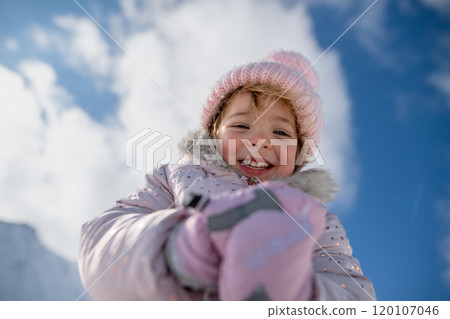 Portrait of small girl enjoying winter holiday in the mountains with family, playing in snow. Portrait of small girl enjoying winter holiday in the mountains with family, playing in snow. 120107046