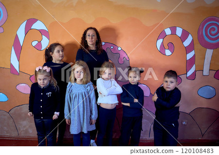 5-7 year old children at an acting class, group photo with their teacher 120108483