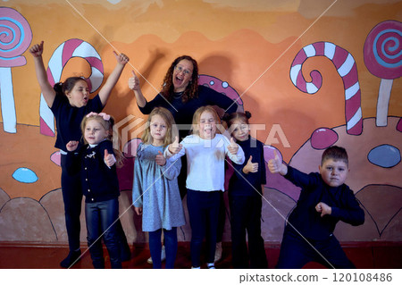 5-7 year old children at an acting class, group photo with their teacher 120108486