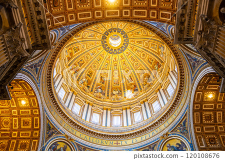 Looking upward at the magnificent dome of Saint Peter Basilica, the intricate designs and warm golden light create a stunning focal point, highlighting the architectural grandeur of the Vatican. 120108676