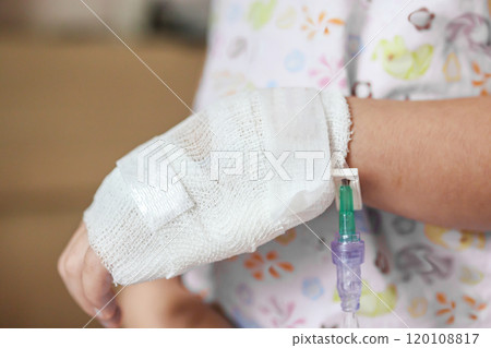 Close up child hand with saline IV solution in hospital 120108817