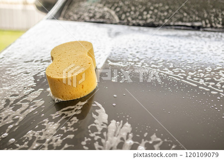 car cleaning and washing with yellow sponge and foam soap 120109079