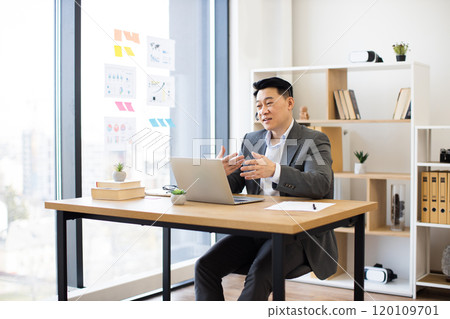 Asian businessman in online video call from modern office Asian businessman in online video call from modern office 120109701