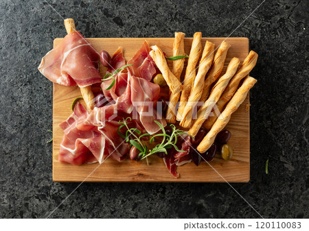 Italian prosciutto with bread sticks, olives, and rosemary. Italian prosciutto with bread sticks, olives, and rosemary. 120110083