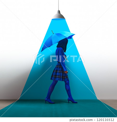 Woman dressed in all blue, holding umbrella, walking under bright blue spotlight. Contemporary art collage. 120110312