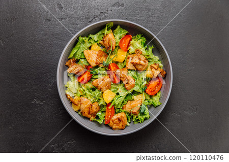 Fresh chicken salad with lettuce, cherry tomatoes, and citrus, perfect for a light and healthy meal 120110476