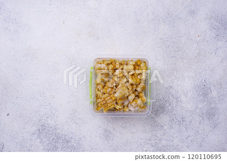Frozen corn in plastic container 120110695