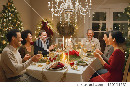 Family and friends celebrating Christmas with a lovely dinner in a room lit by chandeliers and candles 120111581