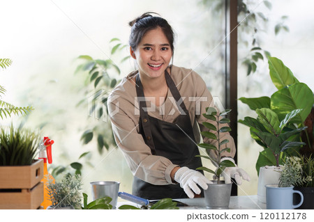 Woman Enjoying Indoor Gardening with Houseplants in a Modern Home Setting 120112178