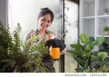 Woman Enjoying Indoor Gardening with Lush Green Plants and Natural Light in a Modern Home Setting 120112180