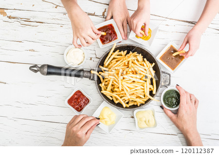 Family having french fries for dinner top view Family having french fries for dinner top view 120112387