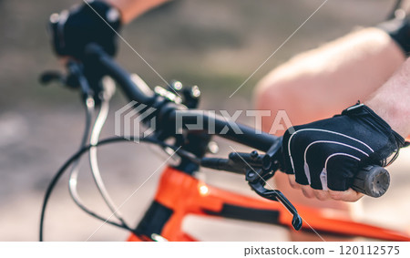 Hands in gloves on bike handlebar Hands in gloves on bike handlebar 120112575