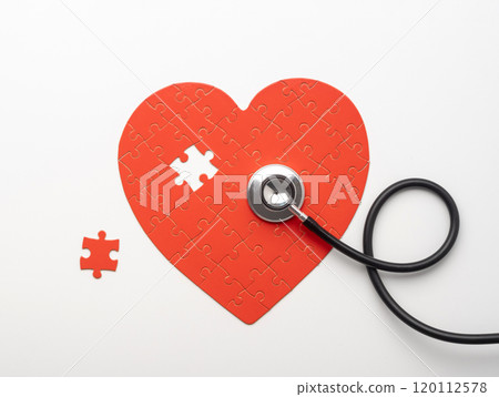 Stethoscope lying on heart shaped puzzle 120112578