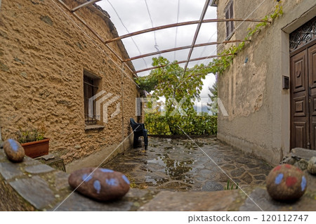 Quiet alley in an old Corsican mountain village with stone walls and rustic architecture 120112747