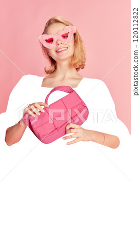 Stylish young woman wearing fluffy pink sunglasses and holding matching pink purse, smiling against pink background with blank white space 120112822