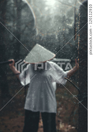 A samurai warrior wearing a traditional conical hat poses with a katana in a misty rainforest. The image evokes a sense of mystery and power from a samurai with a katana in his hands. A samurai warrior wearing a traditional conical hat poses with a katana in a misty rainforest. The image evokes a sense of mystery and power from a samurai with a katana in his hands. 120112910