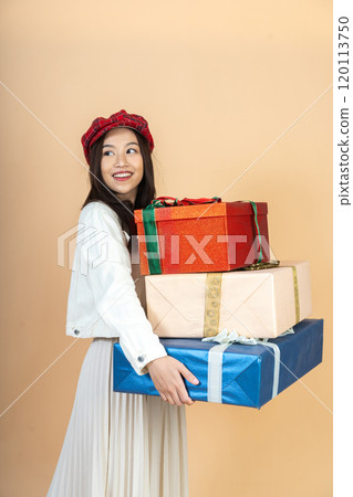 Young Asian Woman with Stack of Holiday Gifts Expressing Surprise and Joy During Christmas Season Shopping Experience in Studio Perfect for Seasonal Marketing 120113750