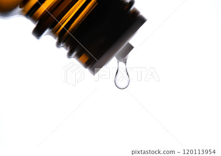 A drop of antihistamine or essential oil drips from a bottle. Close-up. A drop of antihistamine or essential oil drips from a bottle. Close-up. 120113954