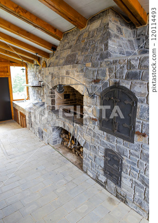 Stone restaurant barbecue firewood, open brick oven cooking food dishes on fire indoors in backyard Stone restaurant barbecue firewood, open brick oven cooking food dishes on fire indoors in backyard 120114493