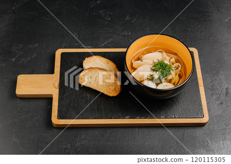 Chicken noodle soup with fresh herbs and toasted bread, cozy and comforting meal for any season 120115305