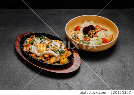 Sizzling skillet breakfast with eggs and potatoes paired with a fresh salad for a balanced meal Sizzling skillet breakfast with eggs and potatoes paired with a fresh salad for a balanced meal 120115307
