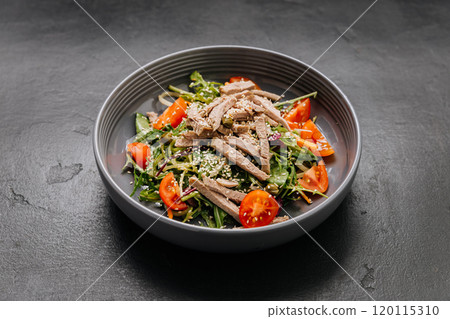 Fresh salad bowl with sliced beef, cherry tomatoes, and sesame seeds. Perfect healthy meal option 120115310