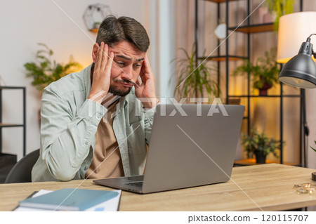 Angry furious man freelancer using laptop working at home office having nervous breakdown at work Angry furious man freelancer using laptop working at home office having nervous breakdown at work 120115707