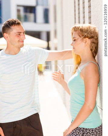 Man flirting with girl on city street 120116959