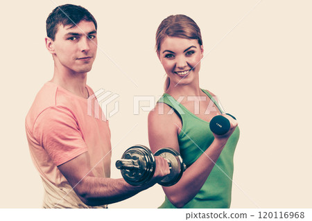 Couple exercising with dumbbells lifting weights Couple exercising with dumbbells lifting weights 120116968