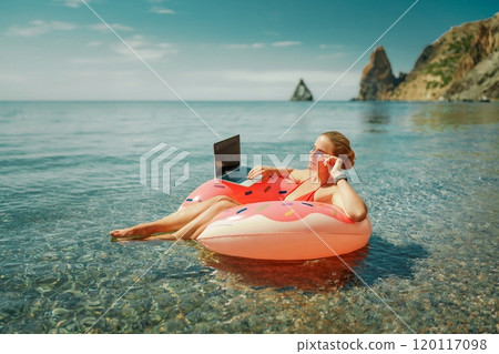 Woman laptop sea. Freelancer woman in sunglases floating on an inflatable big pink donut with a laptop in the sea. People summer vacation rest lifestyle concept Woman laptop sea. Freelancer woman in sunglases floating on an inflatable big pink donut with a laptop in the sea. People summer vacation rest lifestyle concept 120117098