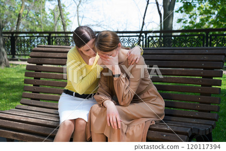 Two girls comfort one another 120117394