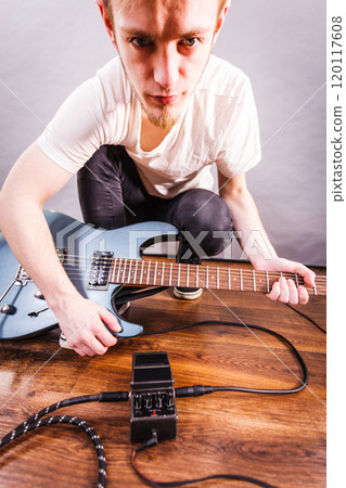 Man setting up guitar equipment Man setting up guitar equipment 120117608