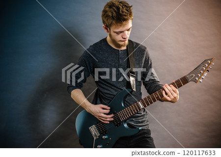 Young man playing electric guitar 120117633