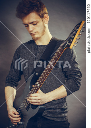 Young man playing electric guitar Young man playing electric guitar 120117660