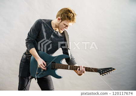 Young man playing electric guitar Young man playing electric guitar 120117674