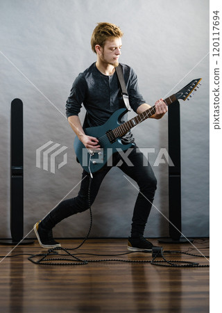 Young man playing electric guitar 120117694