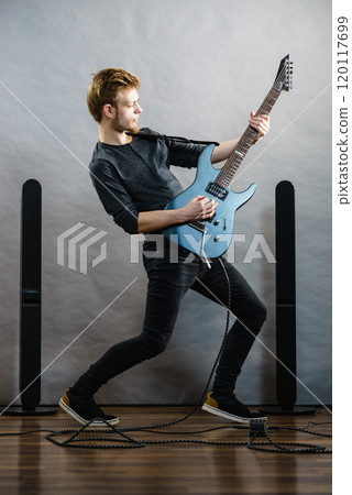 Young man playing electric guitar 120117699