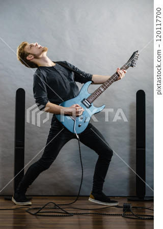 Young man playing electric guitar Young man playing electric guitar 120117700