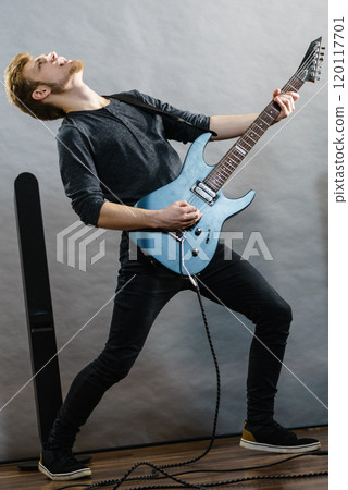 Young man playing electric guitar 120117701