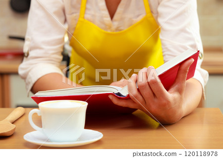 Housewife woman reading cookbook in kitchen. Housewife woman reading cookbook in kitchen. 120118978
