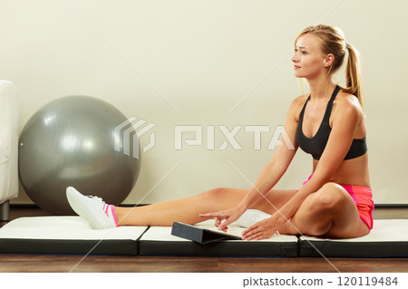Fit woman sitting on floor with tablet pc Fit woman sitting on floor with tablet pc 120119484