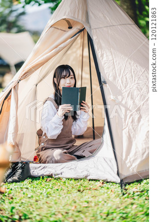 年輕女子在帳篷裡享受讀書 120121863
