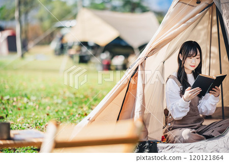 年輕女子在帳篷裡享受讀書 年輕女子在帳篷裡享受讀書 120121864