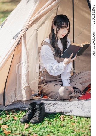 年輕女子在帳篷裡享受讀書 年輕女子在帳篷裡享受讀書 120121865